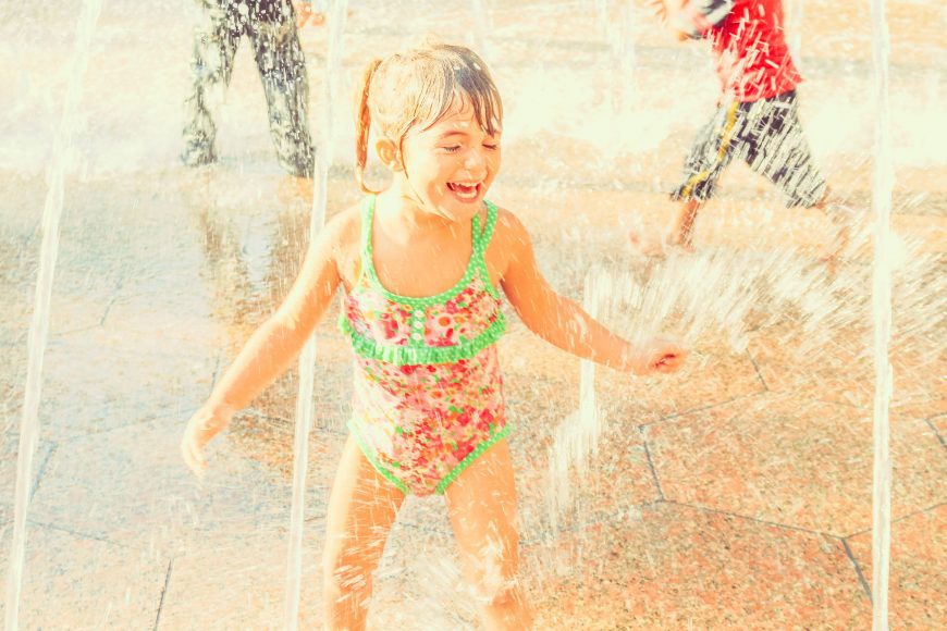 a young girl splaying at a splash pad