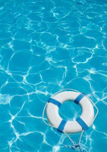 a white life preserver floating in a clear blue pool