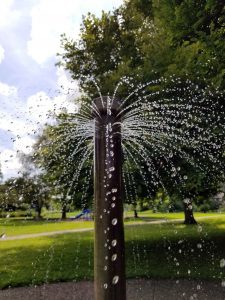 a concrete sprinkler fountain in a park