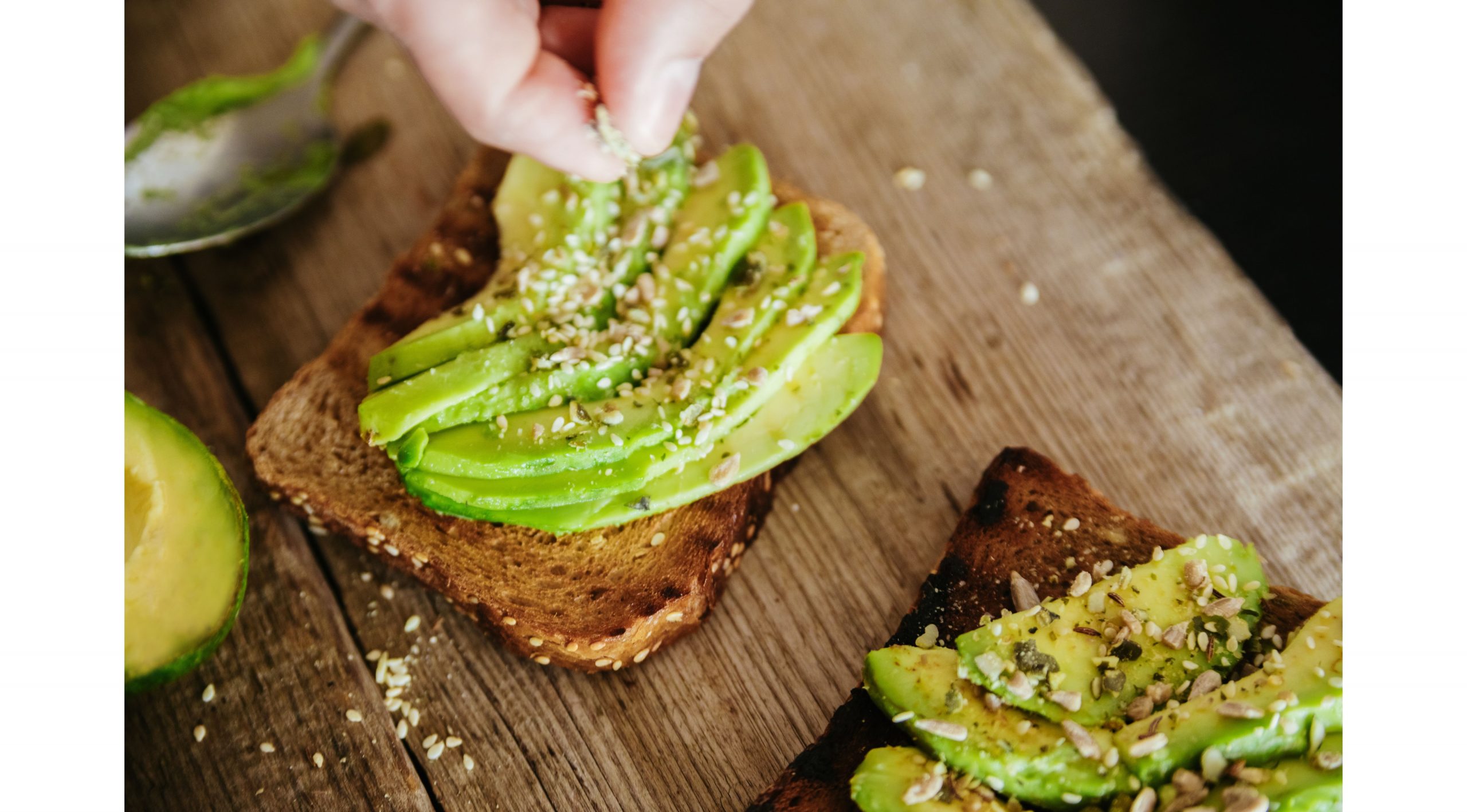 two slices of toast with avocado on top, and seasoning