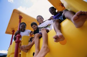 boys sitting on top of a playground play structure