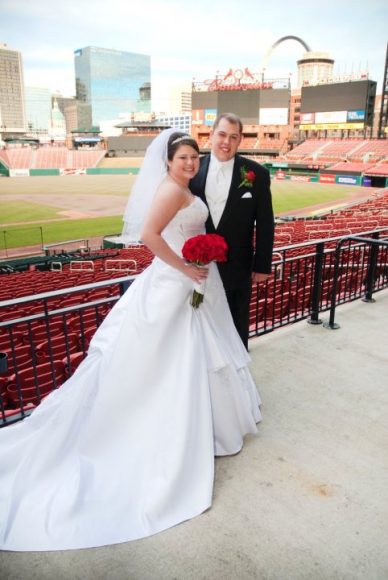 A couple on their wedding day having photos taken at Cardinals stadium.