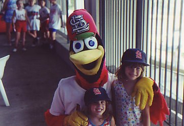 Fredbird, the St. Louis Cardinals mascot, posing with two young girls in the 1990s