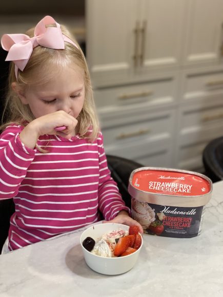 Girl eating Hudsonville Strawberry Cheesecake Ice Cream