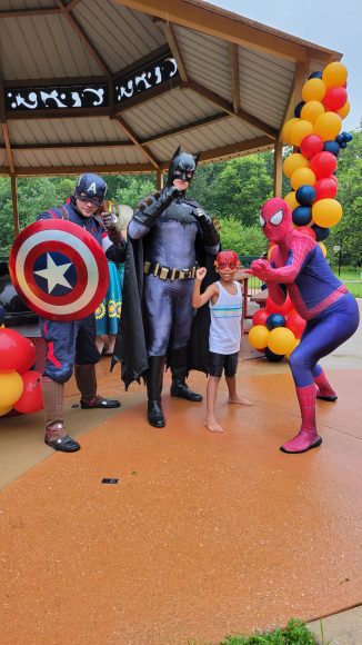 Captain America, Batman, and Spiderman pose with a young boy at STL Mom’s Hanging with Heroes event