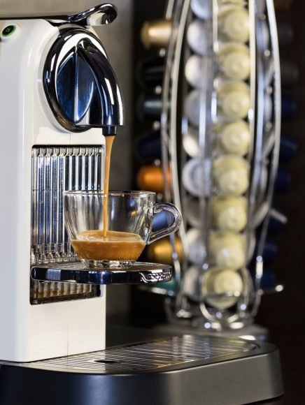 an espresso machine on a countertop, brewing a pod of espresso