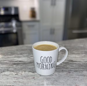 a white mug full of PSL that says, “good morning"