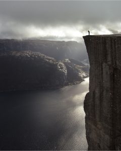 a black and white image of someone standing at the edge of a cliff, symbolic of saving yourself from the edge