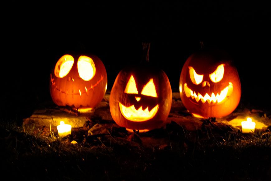 three Jack-O-Lanterns glowing in the dark