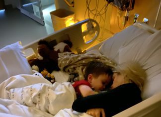 a mom snuggled up in a hospital bed with her child