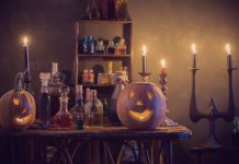 a table with bottles of potions, flanked by lit up jack-lanterns as candles flicker in the background