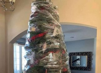 an artificial Christmas tree wrapped in plastic wrap as a mom hack for making putting the tree up easier next year
