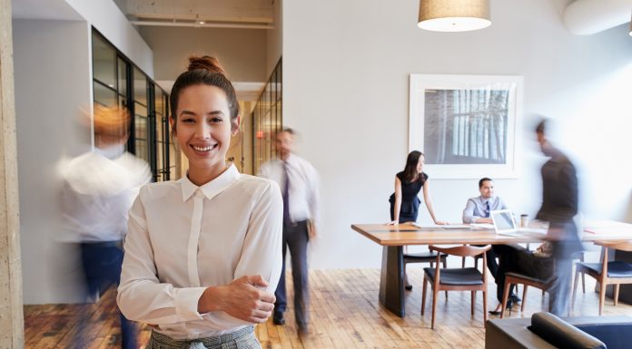 a mom in the workplace, standing in a busy office