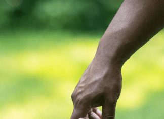 an African American boy holding his father’s hand