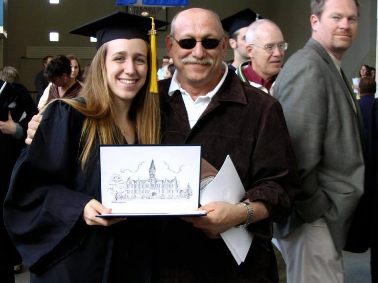 A woman standing next to her dad on her grad school graduation