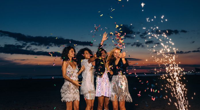 female friends celebrating outdoors with confetti and sparklers