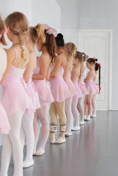 young girls lined up in pink leotards and tutus in dance class