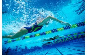 a girl in a swim cap doing laps in a pool