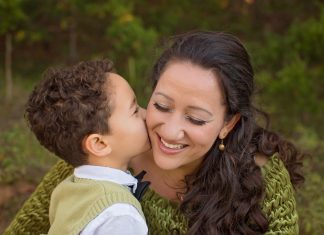 a little boy kissing his mom’s cheek