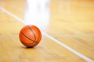 a basketball sitting on a shiny gym floor