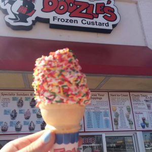 an vanilla ice cream cone with sprinkles in front of Doozles Frozen Custard in St. Louis
