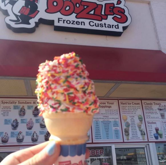an vanilla ice cream cone with sprinkles in front of Doozles Frozen Custard in St. Louis