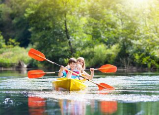 Child on kayak. Kids on canoe. Summer camping.