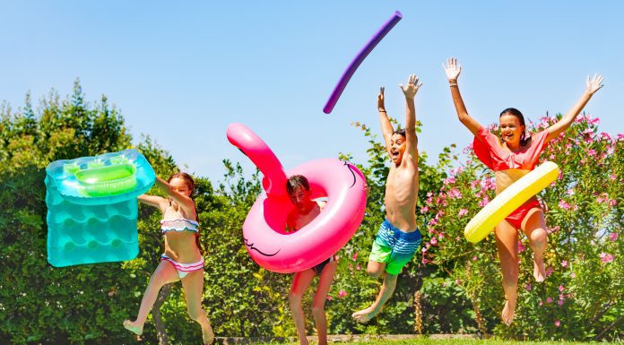 kids with pool floats and pool noodles jumping into a pool