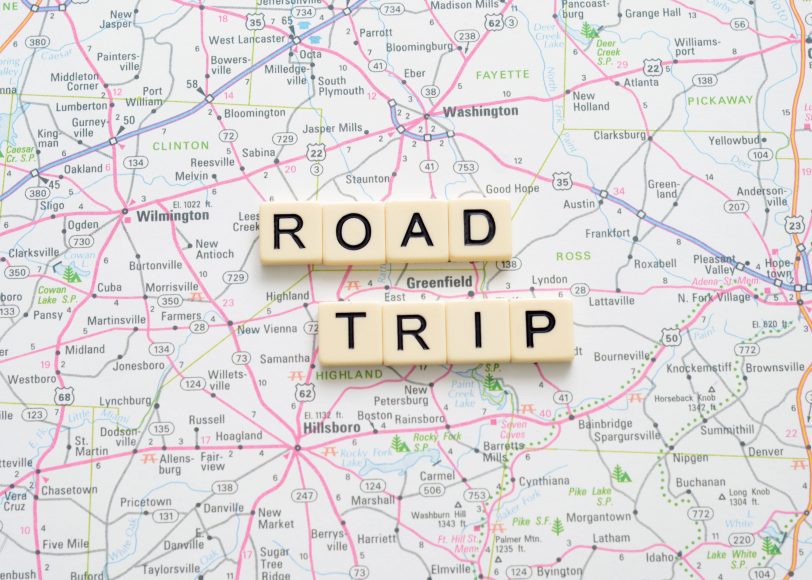 a map with scrabble tiles on it that spell out “road trip"