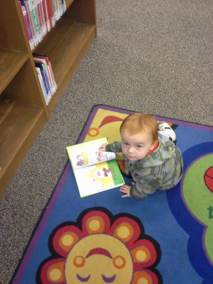 a baby boy on the floor during story time at the library