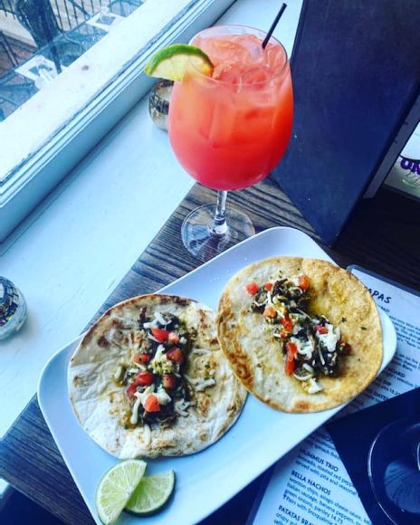 a fruity cocktail and a plate of tacos