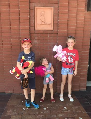 three kids at the St. Louis Cardinals game with Build-A-Bear stuffed animals