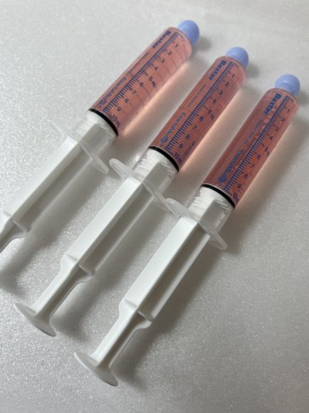 three plastic oral syringes with medicine in them