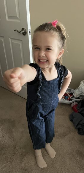 a young girl making an angry face as she points to the camera