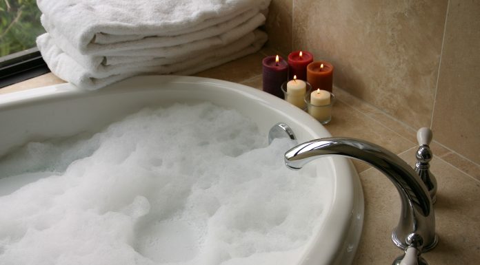 a bubble bath with candles and soft towels symbolizing self-care