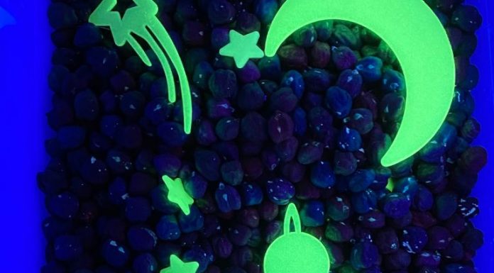 a sensory bin with chick peas and glow in the dark stars and planets under a UV light