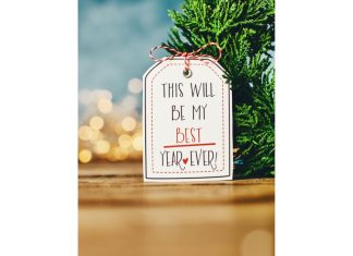 a gift tag on an evergreen branch that reads, “this will be my best year ever” to symbolize new year’s resolutions
