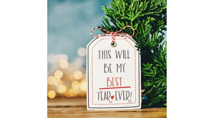 a gift tag on an evergreen branch that reads, “this will be my best year ever” to symbolize new year’s resolutions