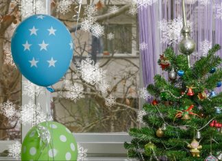a Christmas tree surrounded by birthday balloons, symbolizing the holiday birthday