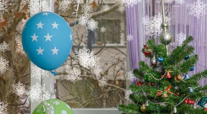 a Christmas tree surrounded by birthday balloons, symbolizing the holiday birthday