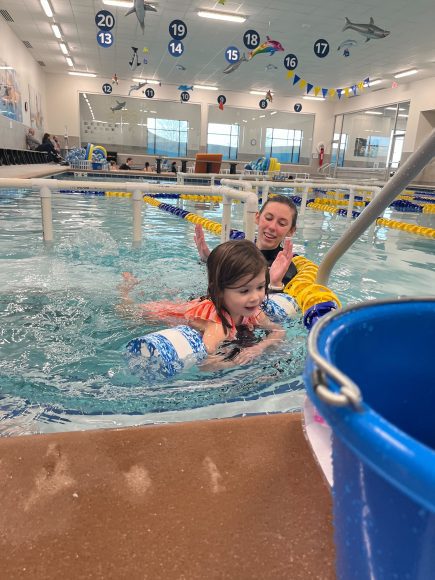an instructor and a student at a swimming lesson at Foss Swim School in St. Louis