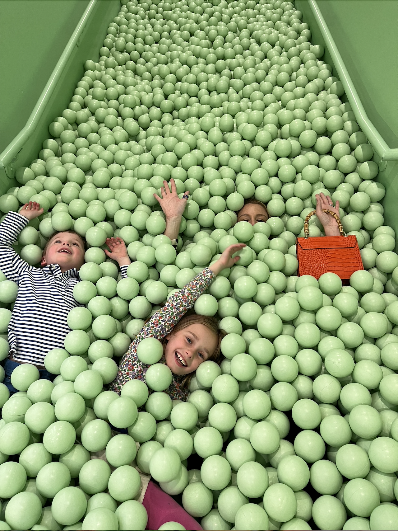 a mom and her two kids in a ball pit at The Color Factory in Chicago