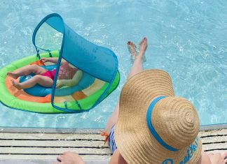 a woman lounging by the side of the pool with her baby