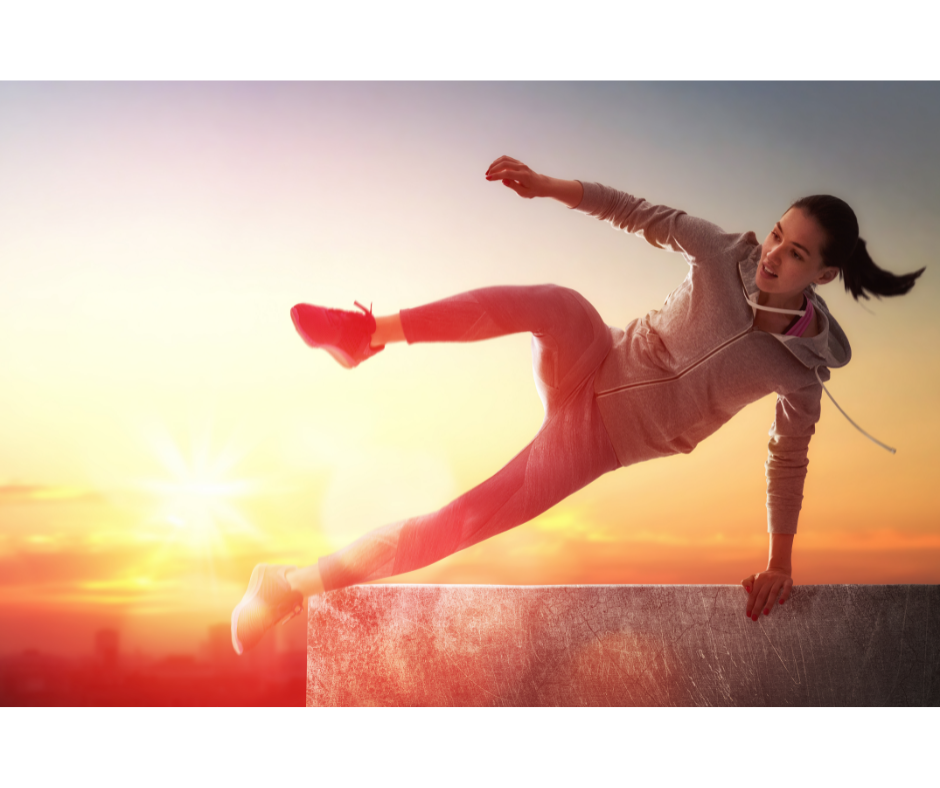a woman leaping in the air as the sun sets behind her