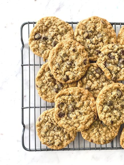a cooling rack filled with oatmeal raisin cookies on a white countertop