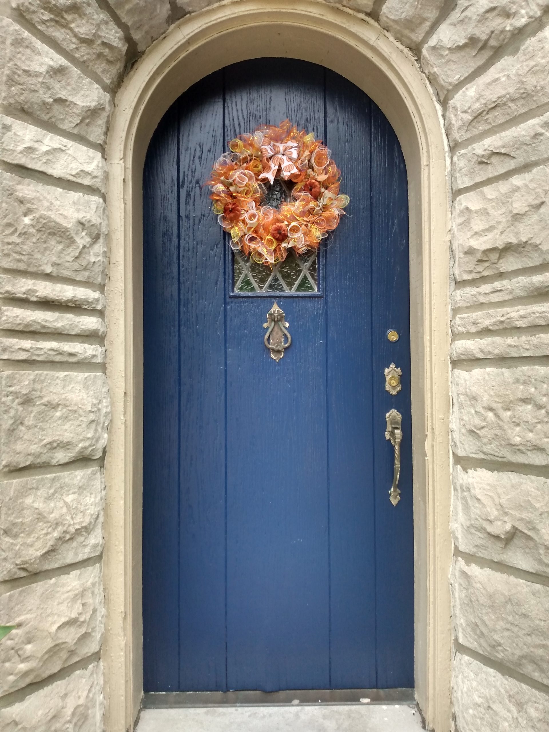a blue door with a seasonal fall wreath