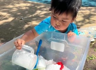 a young boy playing in a sensory bin