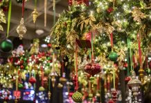 close up of evergreen tinsel with holiday ornaments at a holiday pop-up bar