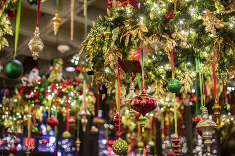 close up of evergreen tinsel with holiday ornaments at a holiday pop-up bar