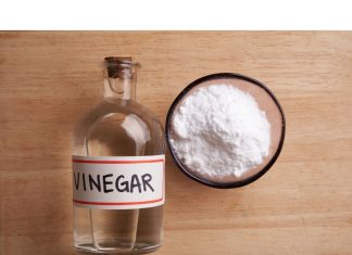 a bottle of vinegar next to a bowl of baking soda